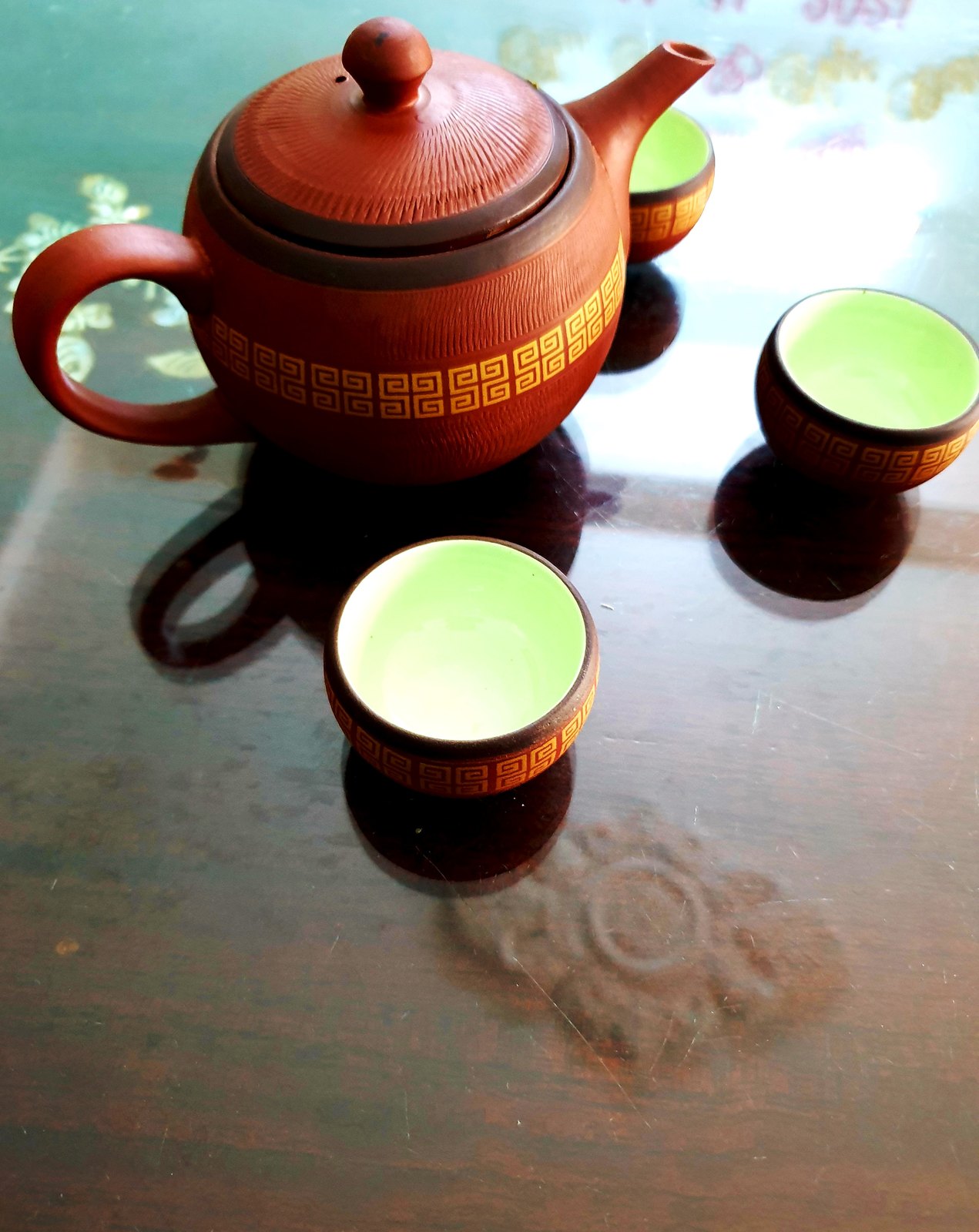 Ảnh mượn theo giấy phép mở — ấm trà đất nung và mấy chén trà xanh trên bàn gỗ, không phải ấm trà của quán này